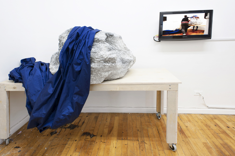 Six ways the water crashes over the shore 2012, 15 min. performance looped on DVD, Cast boulder, cloth, wooden table, 50 x 60 x 36 inches